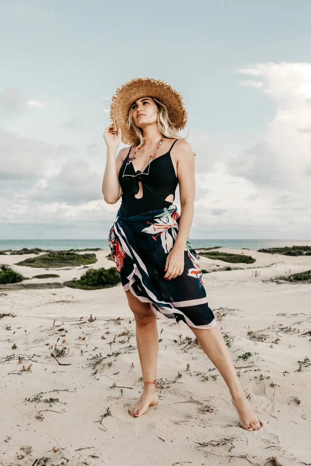 Woman in a printed beach dress and sun hat