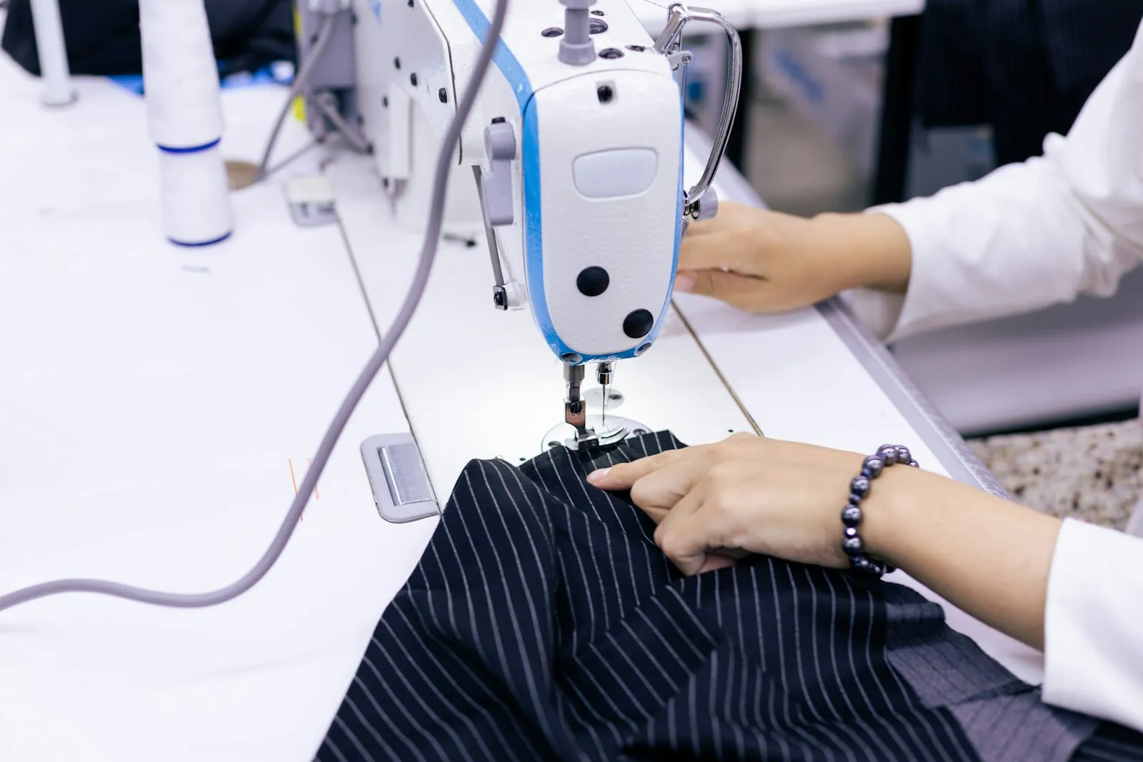 Garment maker sewing striped fabric on a machine