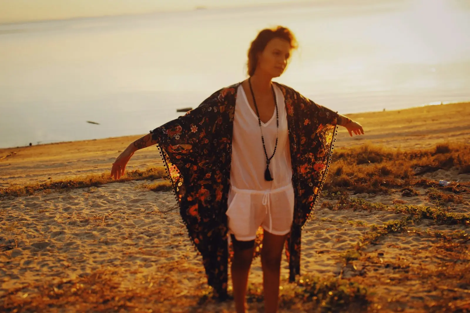 Open printed kimono over a white playsuit at sunset