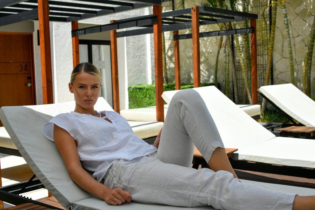 A woman relaxing on a lounge chair by a building.